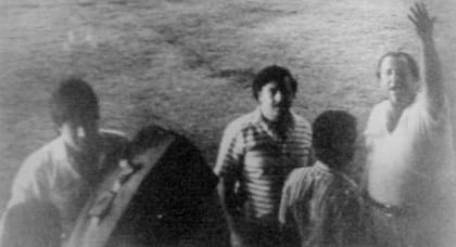 Soldados nicaragüenses cargan sacos de lona llenos de cocaína. Al pie del avión aparece Seal con la mano levantada y Pablo Escobar.
