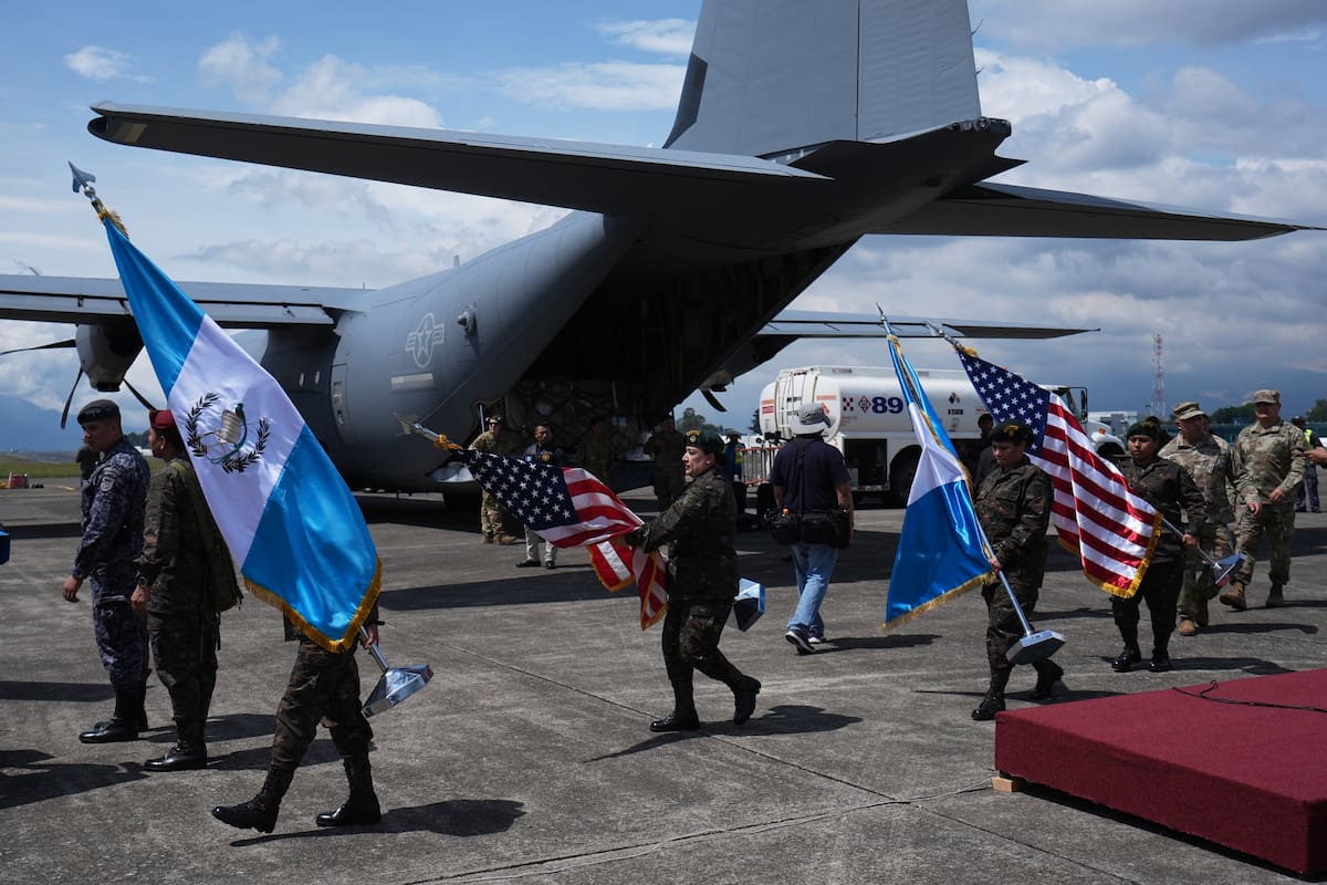 Soldados portan banderas de Guatemala y Estados Unidos mientras se preparan para una ceremonia de re