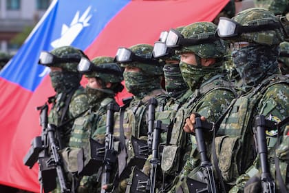 Soldados posan para fotografías con la bandera de Taiwán después de un ejercicio de mejoramiento de preparación de defensa contra intrusiones militares de Pekín, el 11 de enero de 2023