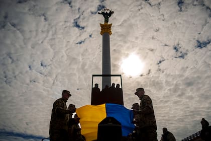 Soldados ucranianos colocan la bandera de su país en el ataúd de su compañero caído Vadym Popelniuk, durante su funeral en la Plaza Independencia de Kiev, Ucrania, el viernes 5 de abril de 2024. (AP Foto/Vadim Ghirda)