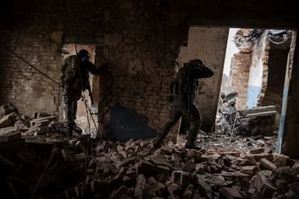 Soldados ucranianos de la 79ª Brigada de Asalto Aéreo avanzando por un edificio dañado en una zona de Marinka, en el este de Ucrania, el 26 de febrero de 2023.