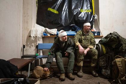 Soldados ucranianos que resultaron heridos en el campo de batalla esperan ser dados de alta de un hospital de campaña en Bájmut, Ucrania, el domingo 26 de febrero de 2023. (AP Foto/Evgeniy Maloletka)