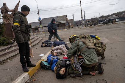 Soldados ucranianos tratando de salvar a un hombre, el único de las cuatro personas que en ese momento todavía tenía pulso, momentos después de ser alcanzado por un mortero mientras intentaba huir de Irpin, cerca de Kiev, el domingo