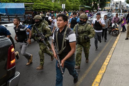 Soldados y policías avanzan detrás de un vehículo blindado mientras seguidores del candidato presidencial Daniel Noboa asisten a un acto político con el aspirante en la ciudad de Esmeraldas, Ecuador, el viernes 6 de octubre de 2023