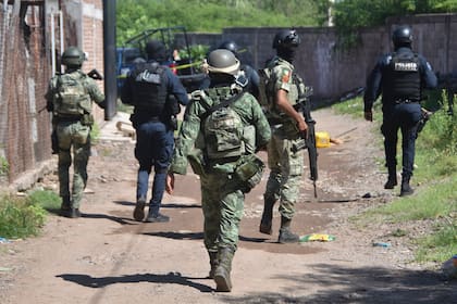 Soldados y policías llegan al área de la zona en la que cuerpos yacen en el piso en Culiacán, en el estado de Sinaloa, México, el martes 17 de septiembre de 2024. El presidente Andrés Manuel López Obrador responsabilizó el jueves 19 de septiembre de 2024 a Estados Unidos de la ola de violencia desatada desde la semana pasada en Sinaloa. (AP Foto)