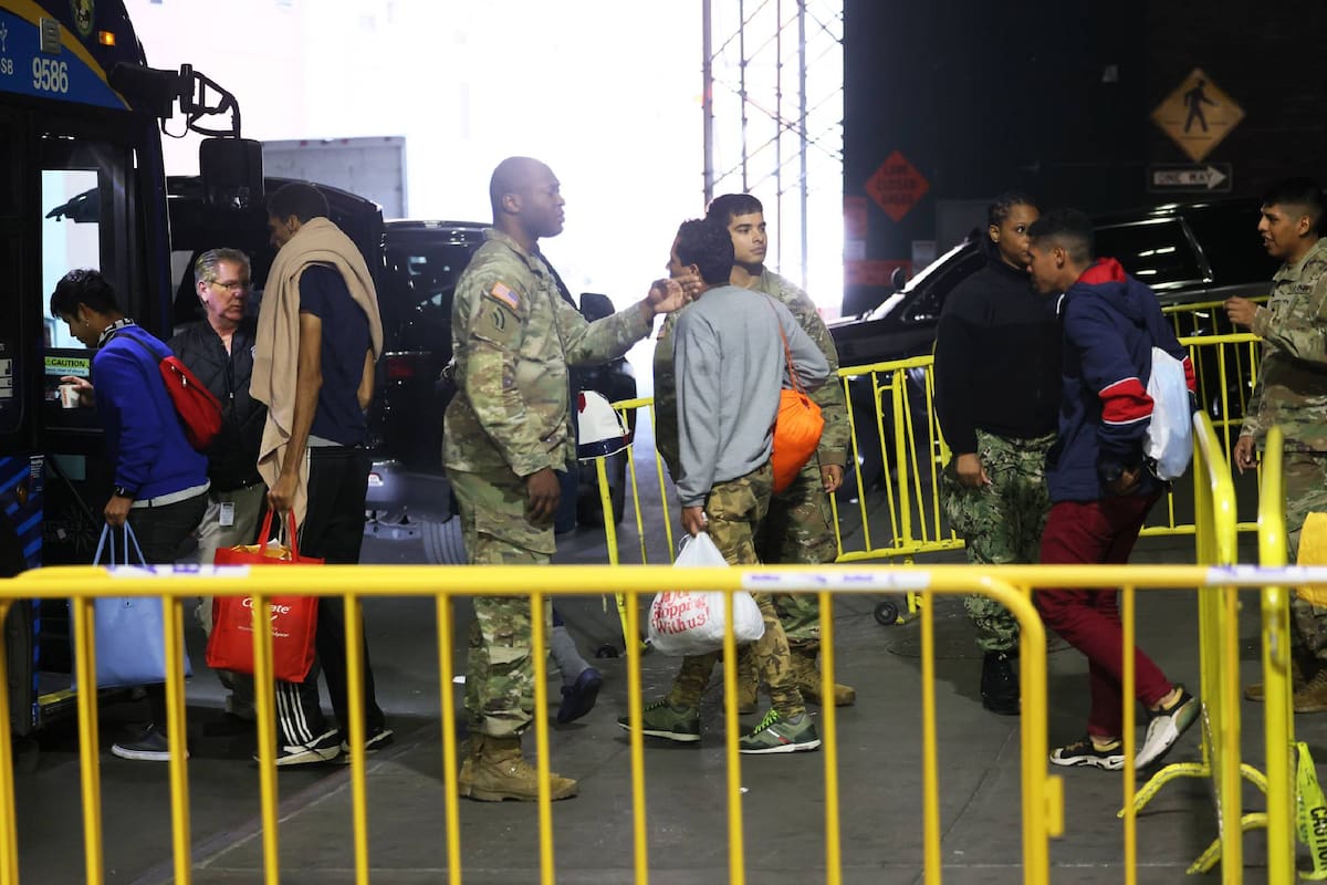 Solicitantes de asilo abordan un autobús de camino a un refugio en la terminal de autobuses de la Autoridad Portuaria, el 18 de mayo de 2023, en la ciudad de Nueva York
