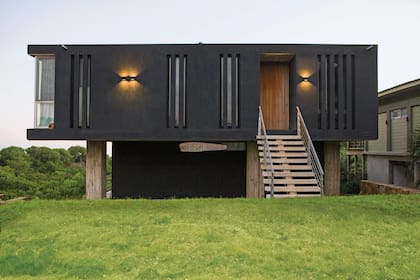 “Sólido, simple y contemporáneo”, así define el arquitecto Martín Gómez el aspecto exterior de esta casa que hizo en José Ignacio. Revestimiento texturado negro (Tarquini). Apliques de aluminio (Darko Lighting).