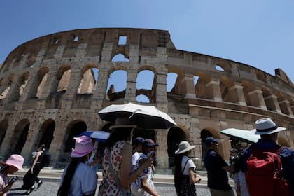 Sombrillas y sombreros entre los turistas que recorren las vistas de Roma