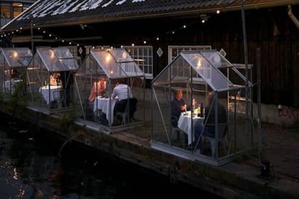 Son cabinas cerradas y transparentes a las que llaman "invernaderos de cuarentena". Permiten que las personas salgan a comer y mantengan la distancia social.