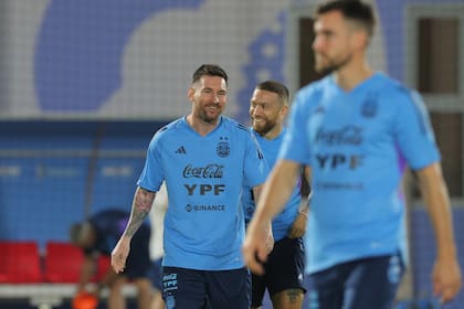 Sonrisas para Messi y Papu Gómez, durante el último entrenamiento de la Selección Argentina; delante de ellos, Nicolás Tagliafico