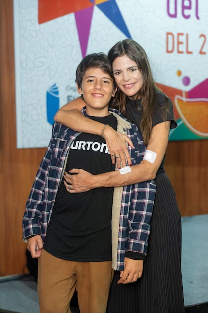 Sonsoles abrazada a su hijo León, de 13 años. “Al primero que le dedico el libro es a él, porque llegué a mi casa con un tubo en el cuello y me miró y me dijo ‘todo bien ma, parecés un robot. No pasa nada, no es tan grave’, contó ella.