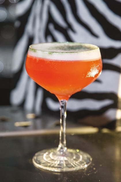 Spider from Mars. En una copa coupé, una mezcla de Aperol y Campari con almíbar de jengibre y ciboulette, jugo de limón y dos golpes de triple sec. Para terminar, un brillante soplo de purpurina. Bar: Kinky