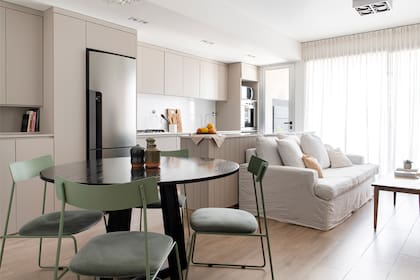 Spots de embutir en aluminio aseguran buena luz en la cocina sin sumar elementos visibles. Como la heladera no era panelable, se hizo un mueble que la contiene para que no sobresalga.