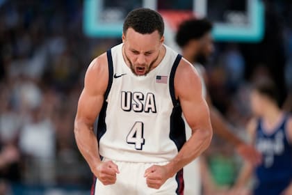 Stephen Curry (4) festeja un enceste para Estados Unidos en la victoria ante Serbia en las semifinales del baloncesto masculino de los Juegos Olímpicos de París, el jueves 8 de agosto de 2024. (AP Foto/Mark J. Terrill)
