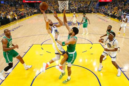 Stephen Curry, de los Warriors de Golden State, ataca la canasta con la marca de Jayson Tatum, de los Celtics de Boston, durante la primera mitad del Juego 2 de las Finales de la NBA, en San Francisco, el domingo 5 de junio de 2022.  (Kyle Terada/Pool Foto vía AP)