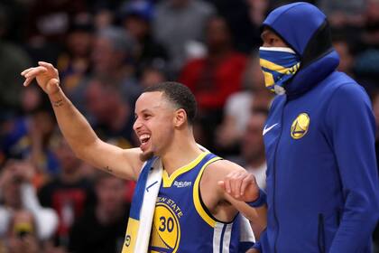 Stephen Curry festeja, Kevin Durant observa dentro de su particular vestimenta: los Warriors quebraron un récord de puntos en la NBA.