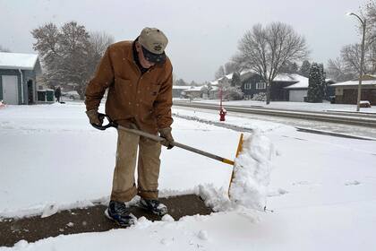 Steve Geisinger quita nieve con una pala el jueves 26 de octubre de 2023, en Bismarck, Dakota del Norte. (AP Foto/Jack Dura)