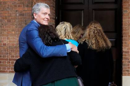 Steve Johnson, hermano de Scott Johnson, abraza a su esposa Rosemarie a su llegada a la Corte Suprema de Sydney, el lunes 2 de mayo de 2022, para una audiencia de sentencia por el asesinato de Scott. (AP Foto/Rick Rycroft)