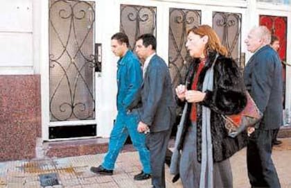 Strajman y sus abogados salen de la casa de Holmberg al 1200, donde sufrió la amputación