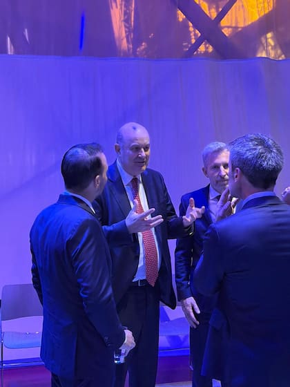 Sturzenegger, junto a Frigerio, charlando con invitados