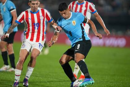 Suárez intenta una gambeta ante el paraguayo Julio Enciso en su último partido en el seleccionado de Uruguay; dejó la Celeste tras 69 goles y 143 presencias.
