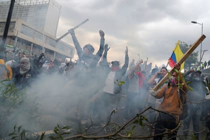 Los manifestantes detrás de una barricada incendiada