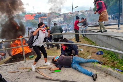 Un manifestante yace en el piso durante el enfrentamiento con la policía