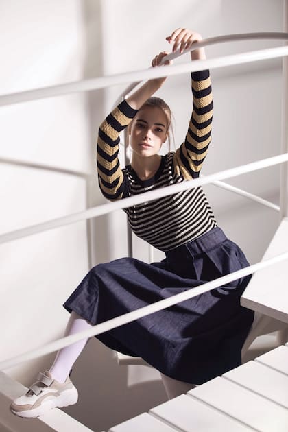 Falda de jean con cinturón (Tommy Hilfiger), suéter de lúrex y zapatillas con abrojos (Vitamina).