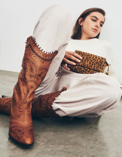 Suéter y pantalón cargo (Prüne), bota texana calada (Rapsodia) y mini bandolera animal print (Prüne)