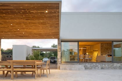 Súper liviana para contrastar con lo sólido de la casa, la pérgola también tiene techo de varillas de madera, que anticipa lo que se verá en el espacio integrado que mostramos en detalle en la foto anterior.