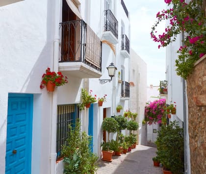 Sus calles estrechas dejan apreciar las casas pintadas de blanco y azul, con sus faroles y balcones llenos de flores
