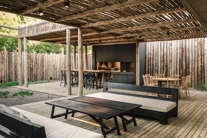 Tabique perimetral de eucalipto tratado y deck de madera de pino tratado (Arq. Miguel Cazalás). Para el techo de la pérgola, eligieron eucalipto de menor diámetro.