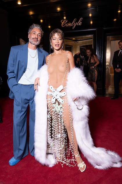 También a tono con el outfit que eligió para la ceremonia de la Met Gala, Rita Ora apareció en la fiesta posterior al evento sin dejar casi nada a la imaginación. Acompañada de su marido, Taika Waititi, la cantante lució un revelador vestido transparente adornado con plumas blancas y flores estratégicamente colocadas