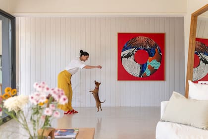 Tamy Selvood, fundadora de Collage Lab, una agencia creativa que integra arte y acciones de marketing, junto con su perrita salchicha.