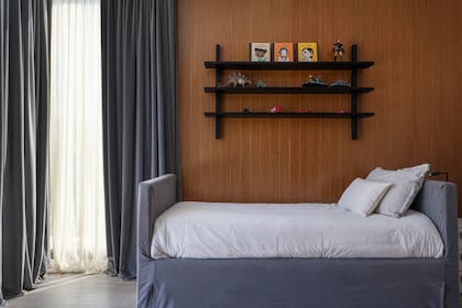 Tanto en el recibidor como en este playroom, a las cortinas de gasa off white les sumaron una capa de black out forrada en pana gris plomo para crear un clima más íntimo.
