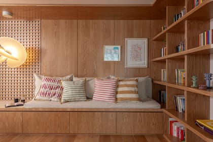 Tanto la biblioteca como el sillón son diseño del Estudio. Los almohadones son estampados a mano (Mercedes Segura). Obras de Milagros Pini y Casa Cuadros.