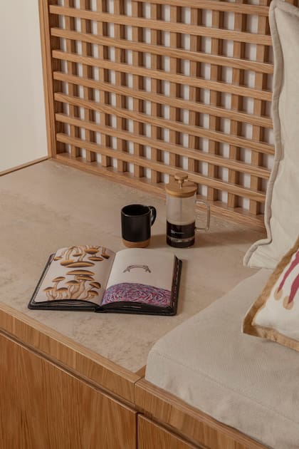 Taza con base de corcho (Mishka) y libro ‘Las visiones’ de Ezequiel Black.