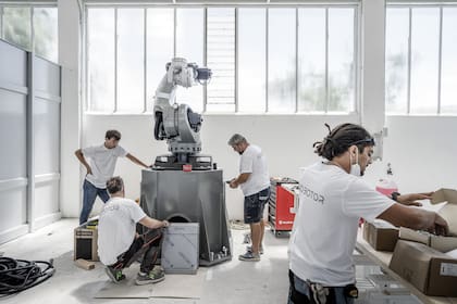 Operarios ensamblan un robot que esculpe en mármol en la empresa Torart, en Carrara, Italia, el mes pasado