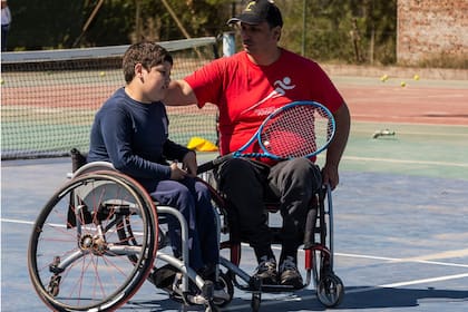 Diego Moliner, organizador del torneo internacional de tenis adaptado en el club Cañuelas, junto con un niño que recién se inicia en la escuela cañuelense de ese deporte.
