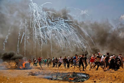 Los palestinos huyen de los gases lacrimógenos lanzados por Israel