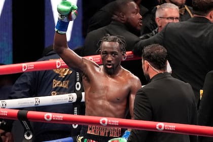 Terence Crawford, centro, levanta el puño al final de la pelea a 12 asaltos contra Israil Madrimov durante una pelea de boxeo por el campeonato de peso súper welter en Los Ángeles, el sábado 3 de agosto de 2024. Crawford, el consenso del mejor boxeador libra por libra del mundo, derrotó a Israil Madrimov por decisión unánime para convertirse en campeón de cuatro divisiones. Crawford ganó el título superwelter de la AMB el sábado por la noche en Los Ángeles en su primera pelea en las 154 libras. (AP Foto/Damian Dovarganes)