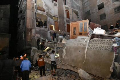 Una foto difundida por la agencia de noticias oficial siria SANA muestra a personas inspeccionando un edificio destruido de 8 plantas en el barrio de Al-Arba'een, en la ciudad de Hama, tras un terremoto de magnitud 7,8 en la frontera entre Siria y Turquía