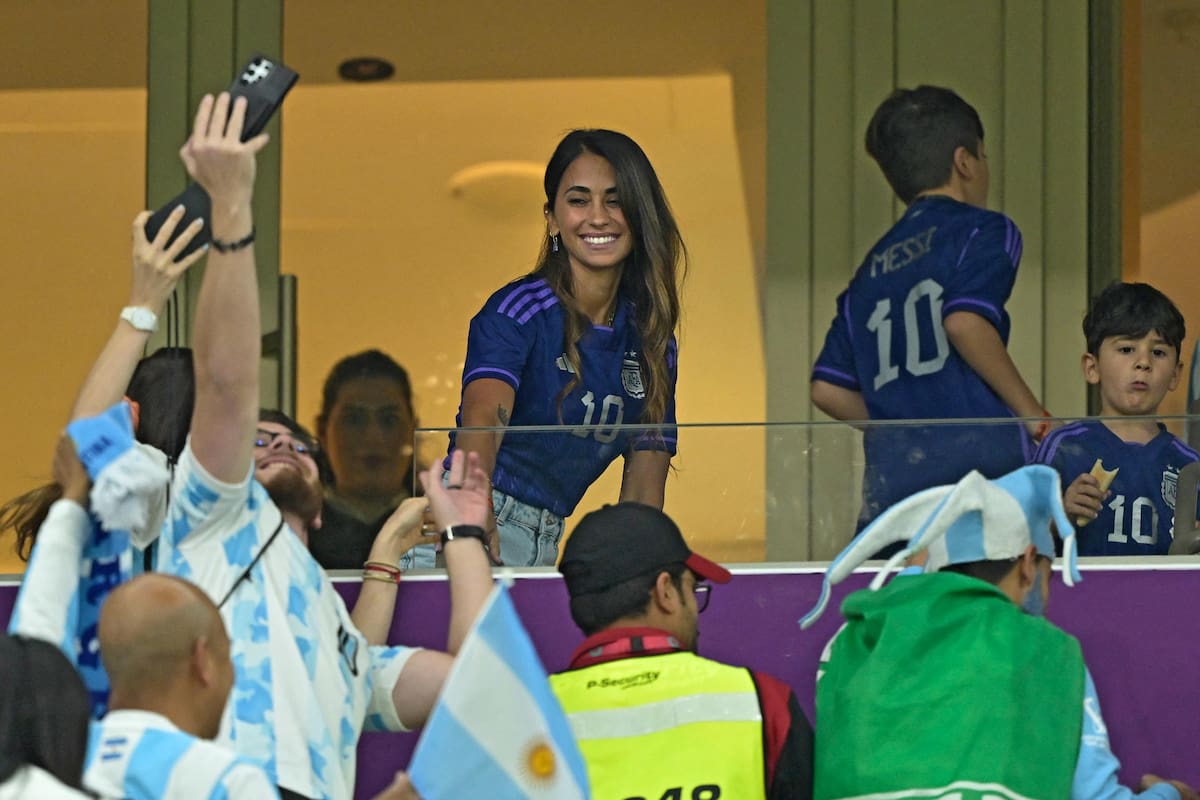 The wife of Argentina's forward Lionel Messi, Antonela Roccuzzo, greets supporters ahead of the Qatar 2022 World Cup football semi-final match between Argentina and Croatia at Lusail Stadium in Lusail, north of Doha on December 13, 2022. (Photo by JUAN MABROMATA / AFP)