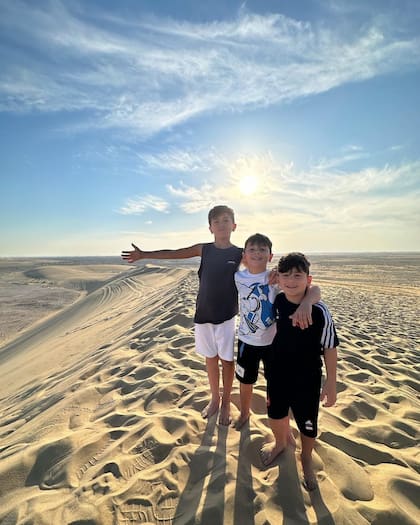 Thiago, Ciro y Mateo posan para la cámara en un desierto de Qatar