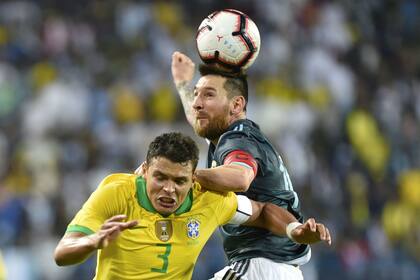 Thiago Silva y Lionel Messi pugnan en el aire por la pelota durante el partido entre Argentina y Brasil disputado en Arabia Saudita.