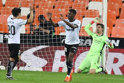 Thibaut Courtois en el piso mientras jugadores del Valencia festejan.