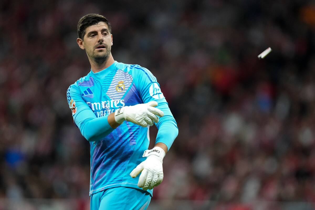 Thibaut Courtois saca uno de los proyectiles que le arrojaron desde la cabecera que ocupaban los hinchas del Atlético de Madrid