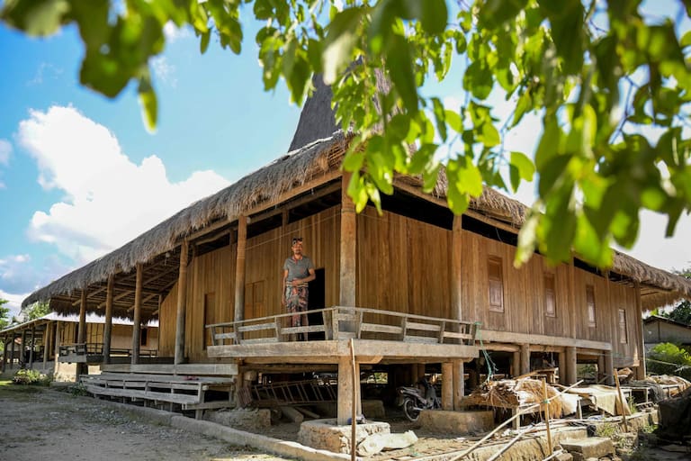 This photo taken on June 24, 2026 shows Umbu Remi Deta, a maramba (nobleman) standing on the veranda of a traditional Sumbanese house at Kampung Raja Prailiu at Waingapu in East Sumba, East Nusa Tenggara. Two hours from the tourist beaches of Bali, slavery is alive and well on the Indonesian island of Sumba, where people are still being born into bondage. Eight of out 10 of Sumba's population of 685,000 people are Christian but its older "marapu" belief system, that blends animism and ancestor worship, has deep roots. It divides society into three castes, "the nobles, called 'maramba' -- often large landowners -- ordinary people called 'kabihu' and the slaves/servants, the atas," said rights activist Martha Hebi, author of several studies on the subject. (Photo by BAY ISMOYO / AFP) / To go with Indonesia-Sumba-slavery, SPECIAL REPORT by Eric Bernaudeau