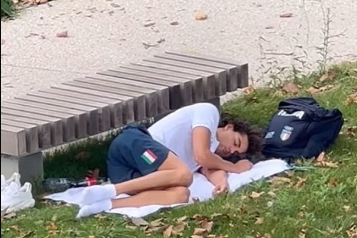Thomas Ceccon durmiendo en una plaza tras quejarse de las condiciones de las habitaciones de la Villa Olímpica.