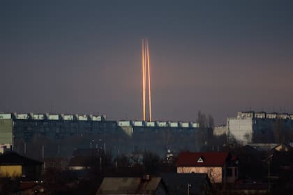 Three rockets launched against Ukraine from Russia's Belgorod region are seen at dawn in Kharkiv, Ukraine, Thursday, March 9, 2023. (AP Photo/Vadim Belikov)